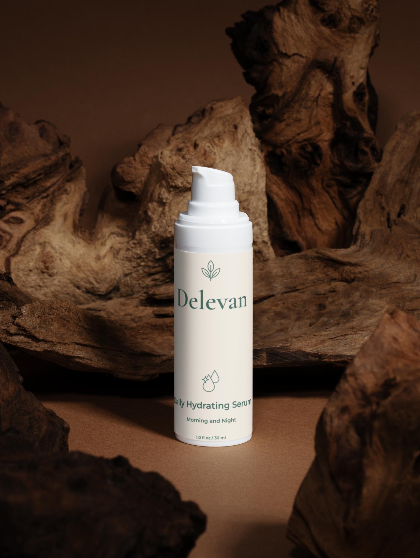 Delevan hydrating serum bottle on a wooden surface with a warm brown background