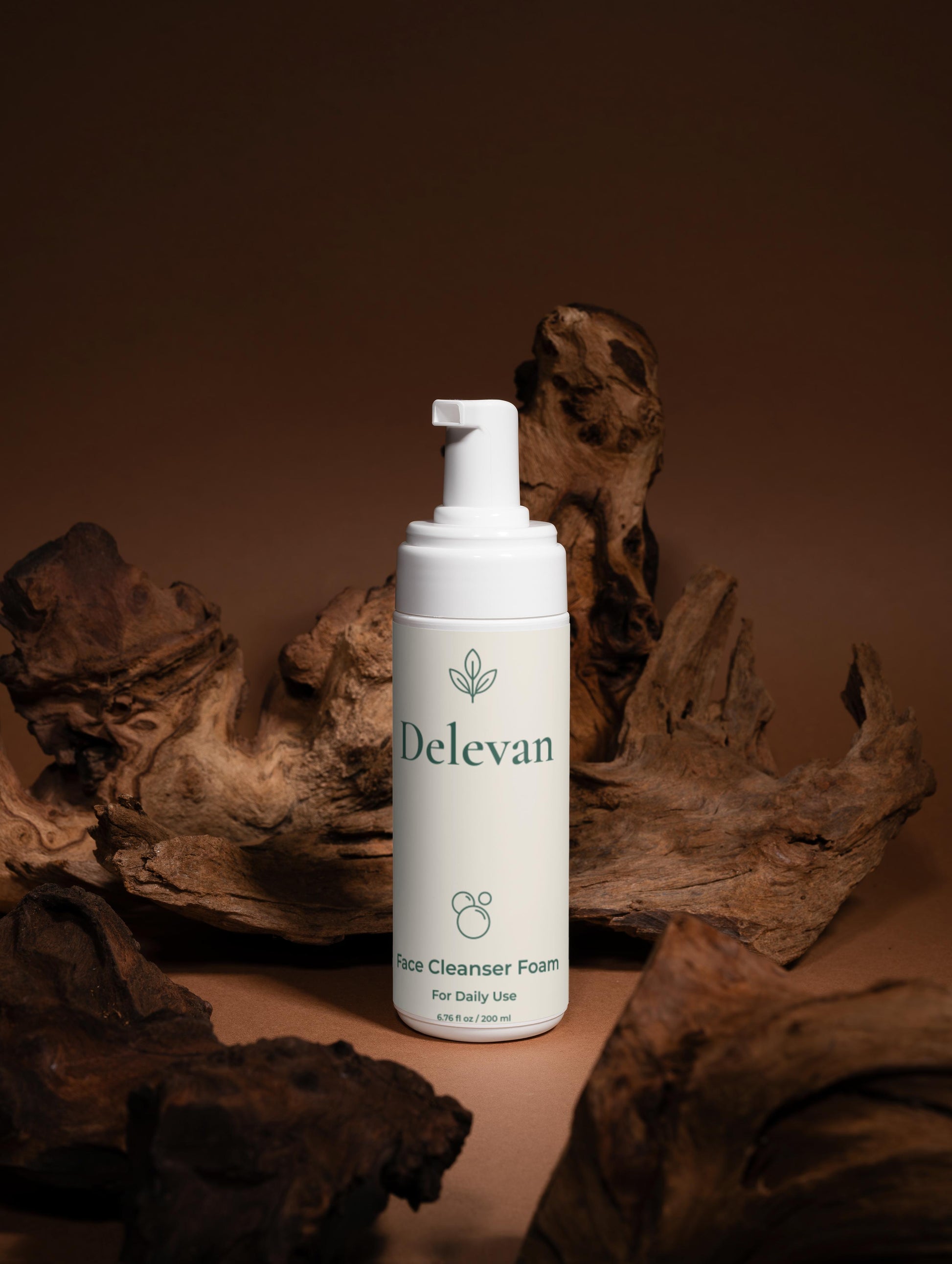 Delevan face cleanser foam bottle on a brown background with natural wood elements